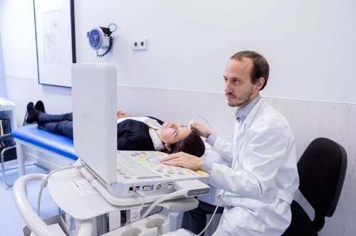 врач проводит диагностику головы ультразвуковой допплерографией